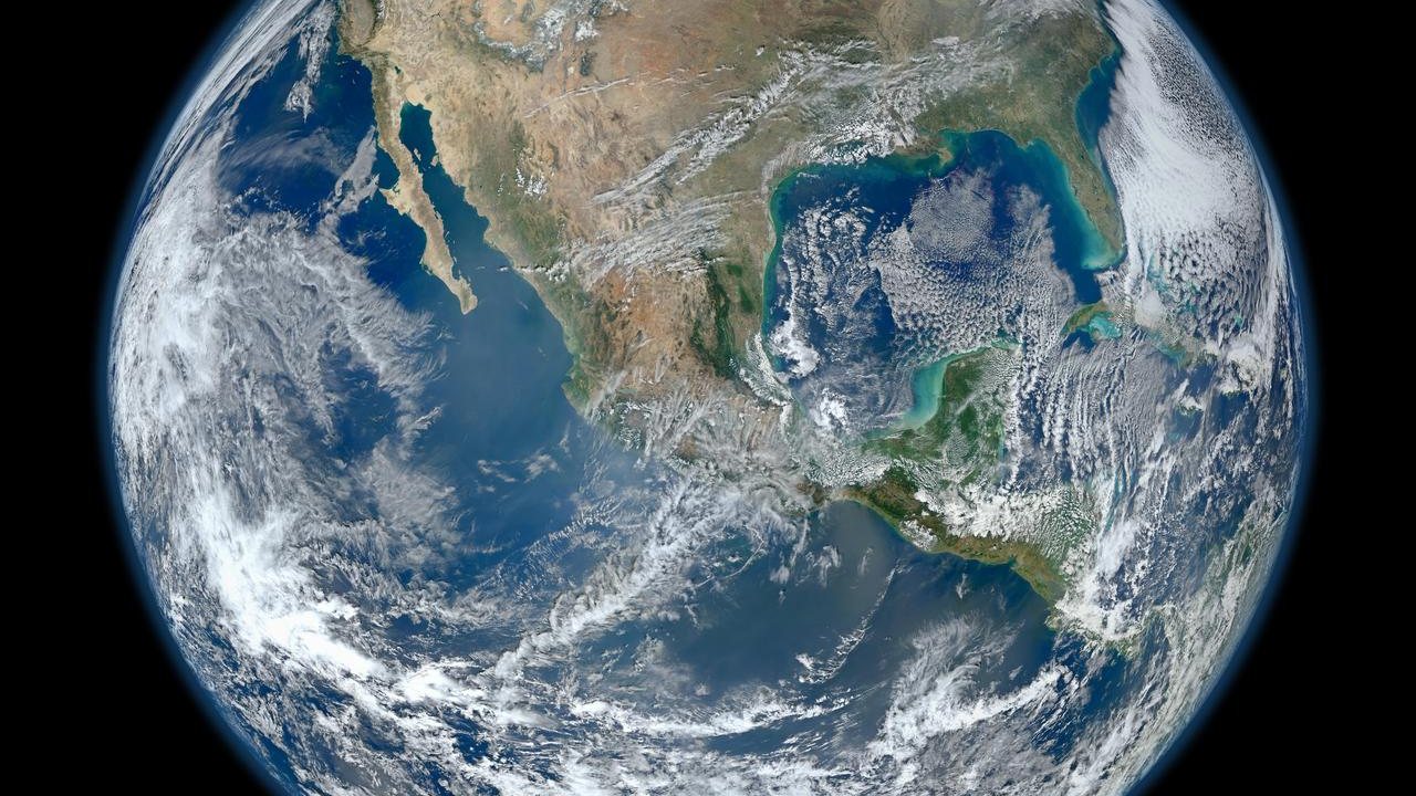North America photographed from orbit, ringed by ocean and cloud bands