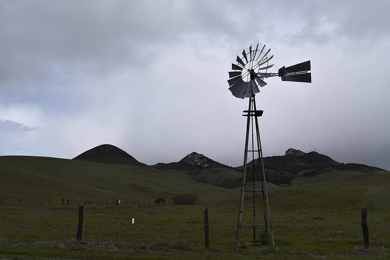 Rare Eclipse water-pumping windmill near Los Osos, California (near Morro Bay) with a string of ancient volcanic necks in the background.