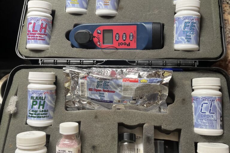 A water test kit with reagent bottles and a handheld photometer in a foam case